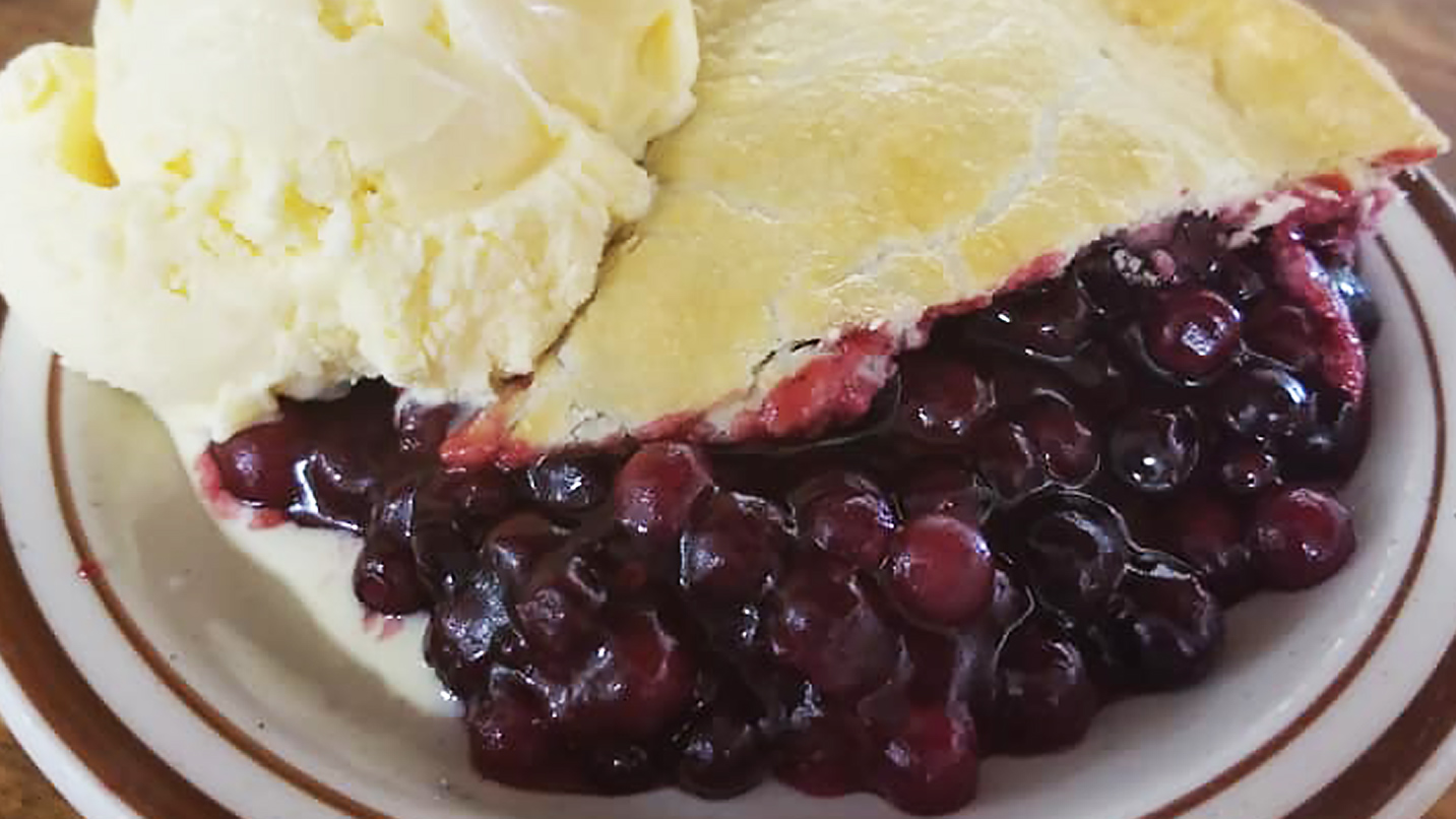 Closeup of a slice of marionberry pie a la mode.