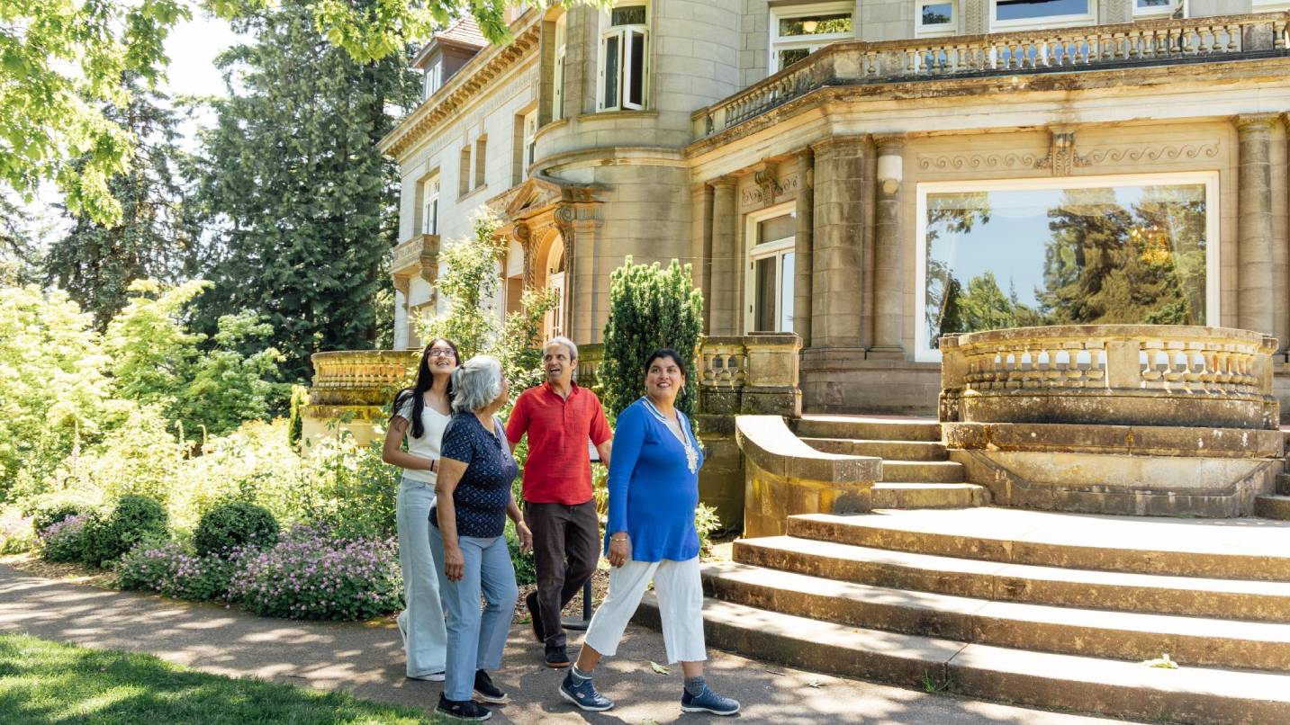 A family walks along a path at Pittock Mansion.