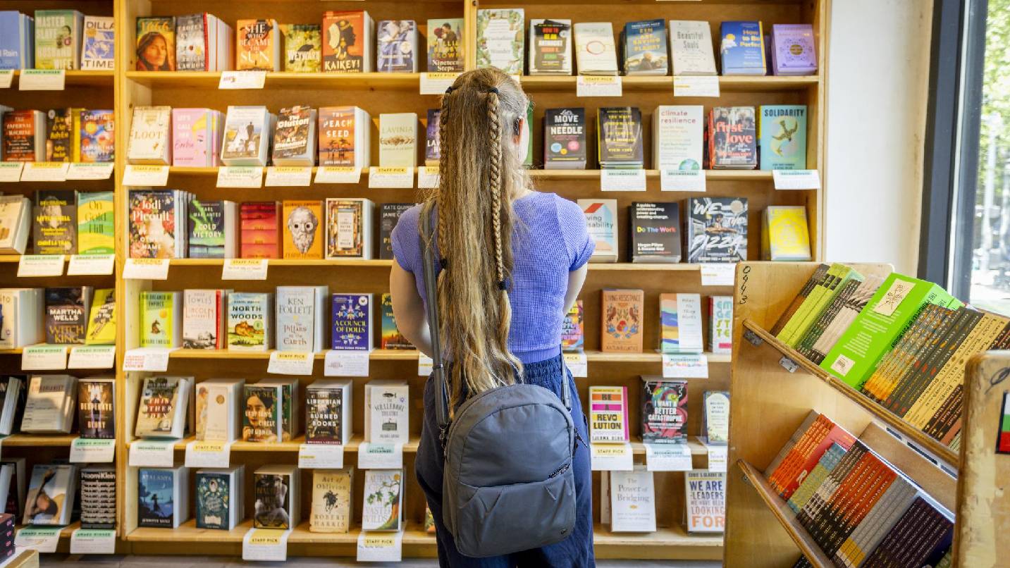 Una mujer mirando estanterías de libros en Powell's.