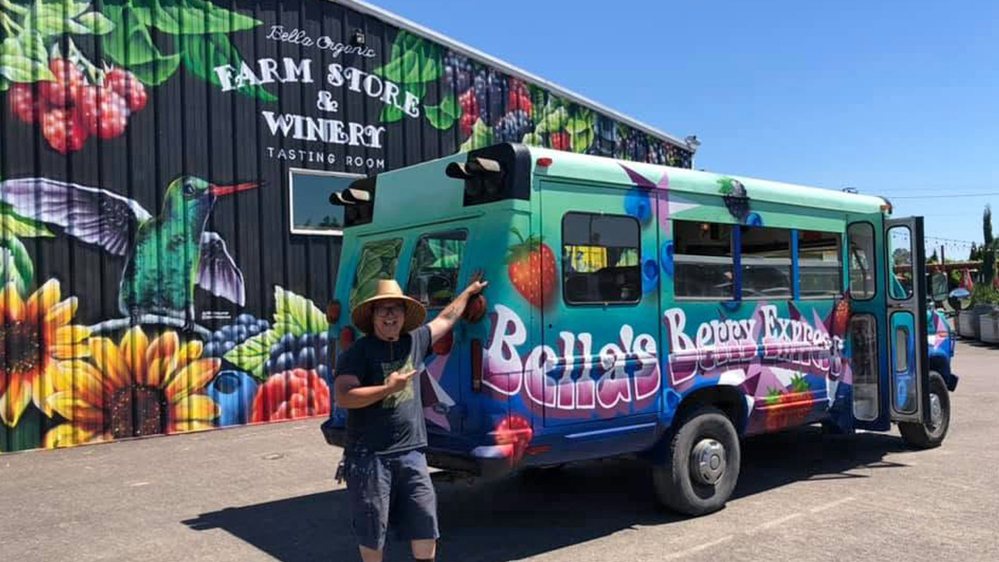 A colorful "Berry Express" bus next to a mural.