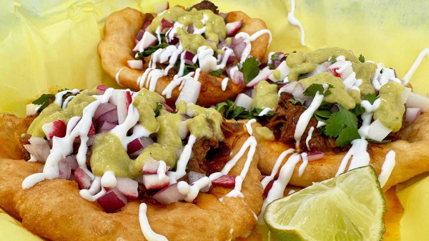Three fry bread tacos, loaded with meat, guacamole, sour cream and onions.