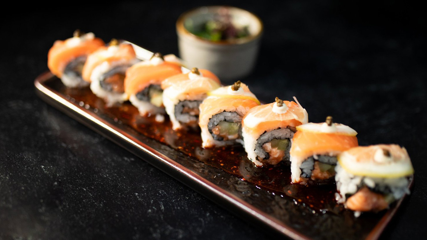 A plate of sushi topped with salmon.