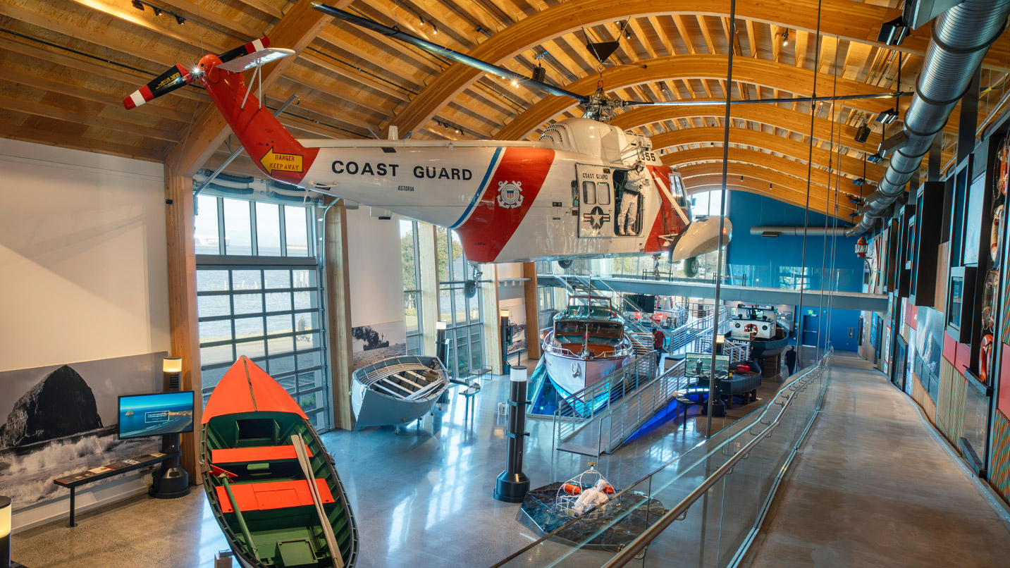 A helicopter hangs from a ceiling inside a museum.