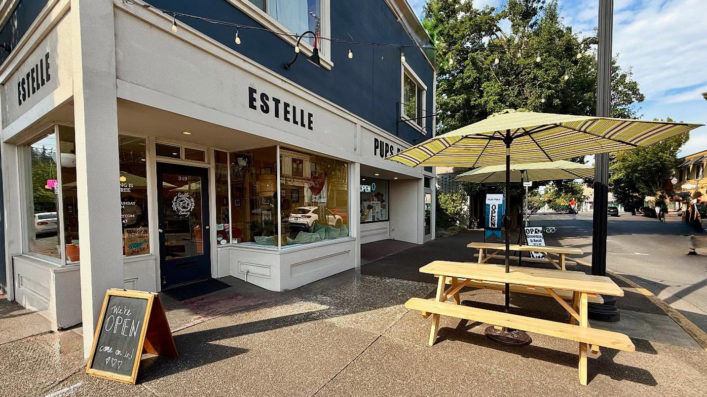 Exterior of a bakery, Estelle, with picnic tables on their sidewalk.